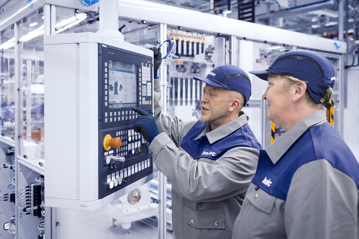 Two Leadec employees checking the display of an automatic station.
